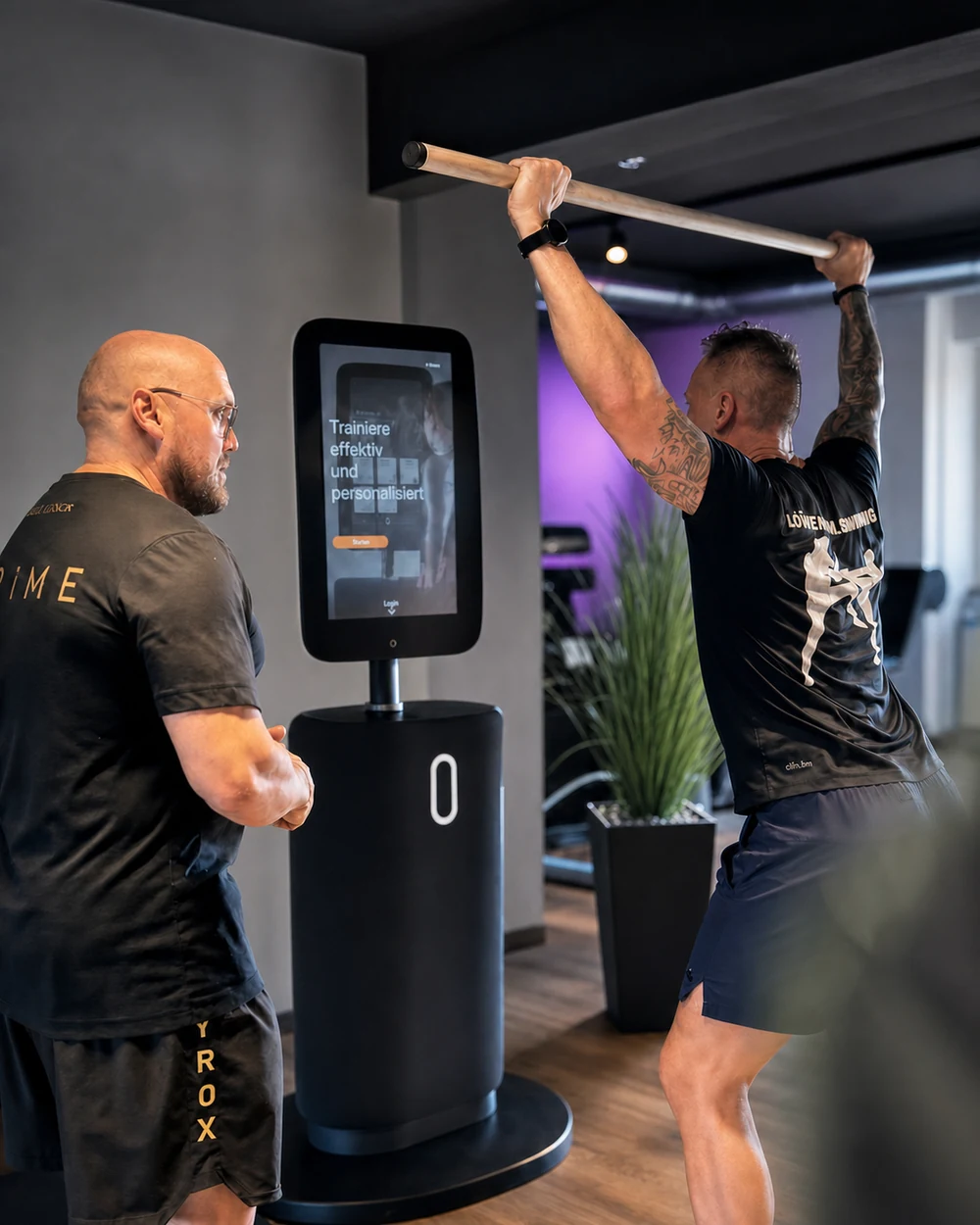 Trainer Mirko begleitet ein Mitglied bei der Bio-Age-Messung am Fitness Hub im Fitnessstudio Hohenstein-Ernstthal – Lila Fitness